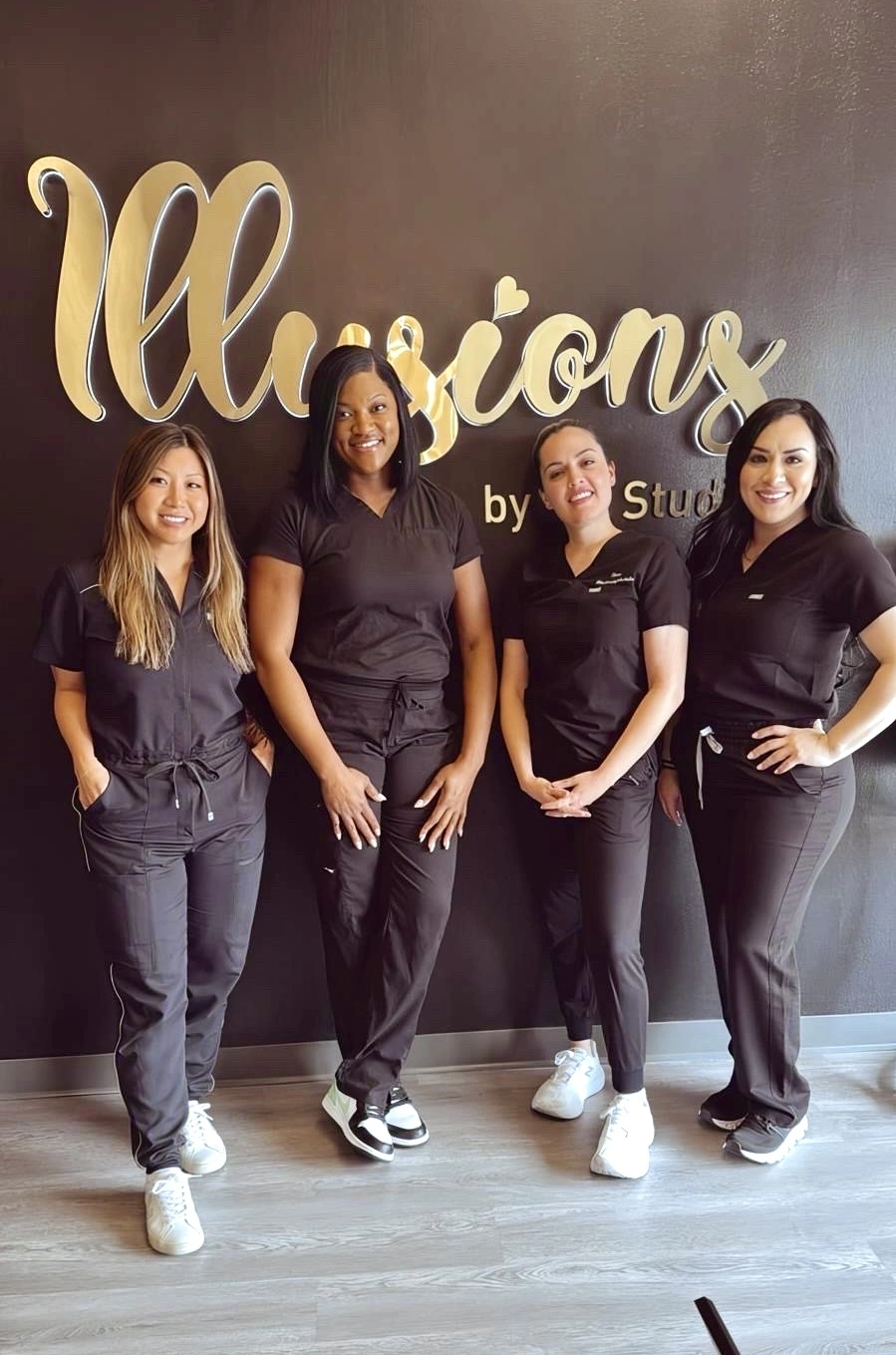 Elena Sanchez leading a group scar camouflage tattoo training class at Illusions by Ink Studio, with students in professional uniforms standing in front of the studio logo.